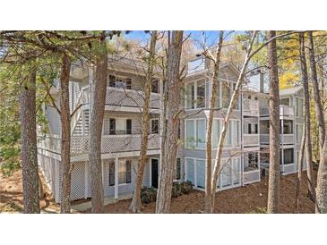 Gray two-story condo with white trim, multiple balconies and wooden stairs at 409 Natchez Trce, Sandy Springs, GA 30350