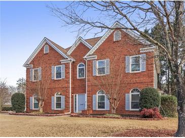 Charming two-story brick home with manicured lawn, classic architectural details, and inviting curb appeal at 1085 Grace Hadaway Ln, Lawrenceville, GA 30043