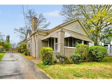 Charming home exterior with brick facade, awnings, and well-manicured landscaping at 1420 Elizabeth Ln, East Point, GA 30344