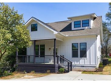 Charming home featuring a covered porch, gray trim, and a well-manicured lawn at 2620 Oak St, Atlanta, GA 30344