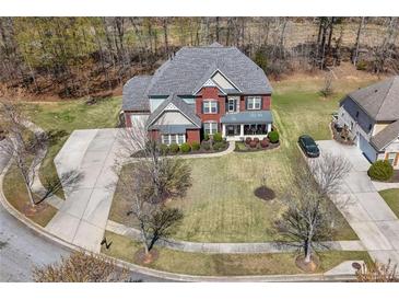 Expansive aerial view of a brick two-story home, landscaped front yard, and wide driveway at 7090 Blue Sky Drive, Locust Grove, GA 30248