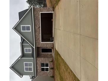 Two-story home featuring a brick facade, a gray exterior, an attached garage and a long concrete driveway at 793 Rock Hill Pkwy, Lithia Springs, GA 30122