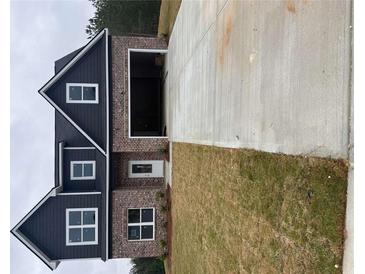 New two-story home with brick and dark siding, attached two-car garage, and a well-sized concrete driveway at 813 Rock Hill Pkwy, Lithia Springs, GA 30122