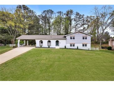 Charming home with arched entryway, carport, and spacious front yard, offering a welcoming curb appeal at 2876 Wendwood Dr, Marietta, GA 30062