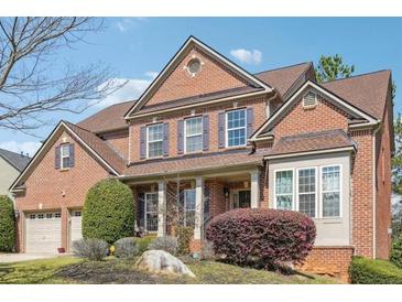 Charming two-story brick home with manicured landscaping and inviting front porch, offering classic curb appeal at 3613 Lake Estates Way, Atlanta, GA 30349