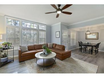 Bright living room featuring a large sectional, wood floors, and many windows at 3636 Habersham Nw Rd # 2103, Atlanta, GA 30305