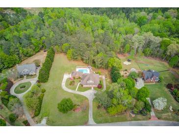Expansive property featuring a home, pool, and lush greenery, offering privacy and space at 5040 Fawn Valley Dr, Loganville, GA 30052