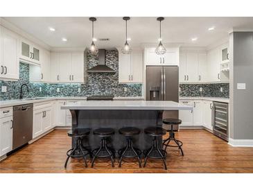 Bright kitchen with a large island, stainless steel appliances, and a mosaic tile backsplash at 708 Mcgill Ne Pl, Atlanta, GA 30312