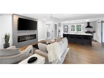 Bright, open-concept living room boasts a modern fireplace, large TV, and seamless flow to the kitchen and breakfast bar at 1251 Pierce Se Ave, Smyrna, GA 30080