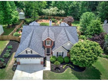 An aerial view showcases the charming home with a manicured lawn, fenced backyard, and well-maintained landscaping at 29 Fern Leaf Ct, Dallas, GA 30157