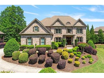 Beautiful brick home with a manicured front yard and lush landscaping at 5330 Cole Creek Ln, Cumming, GA 30040
