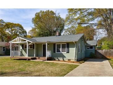 Charming light green home with a welcoming front porch and well-manicured lawn, perfect for curb appeal at 1019 Magbee Se Dr, Smyrna, GA 30080