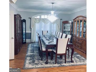 Formal dining room with beautiful chandelier, wooden floor and matching wooden furniture at 3510 Donegal Way, Snellville, GA 30039