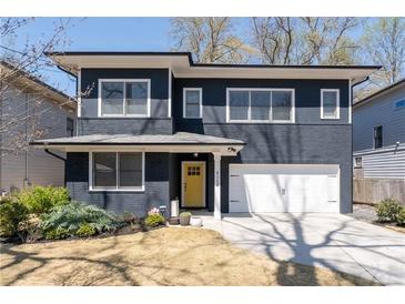 Charming two-story home featuring a painted brick facade, white trim, and a welcoming yellow front door at 4064 Comanche Dr, Tucker, GA 30084