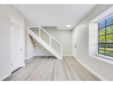 Bright living room featuring hardwood floors, modern staircase, and natural light from the large window at 2622 Terrace Pkwy, Morrow, GA 30260