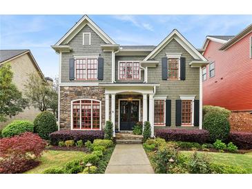 Charming two-story home with stone accents, red framed windows, lush landscaping and inviting curb appeal at 963 Manor Parc Dr, Decatur, GA 30033