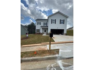 Two-story home features a two-car garage, landscaped yard, and classic black shutters at 803 Rock Hill Pkwy, Lithia Springs, GA 30122