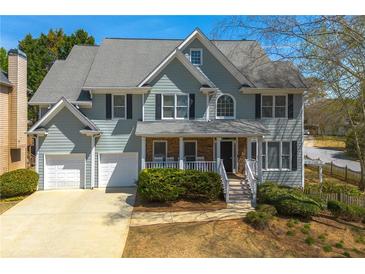Charming two-story home featuring a well-manicured lawn and a two-car garage at 1460 Edgemont Pt, Lawrenceville, GA 30044