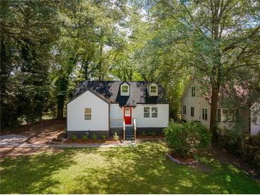 Charming home featuring a bright red front door, manicured lawn, and mature trees at 1956 Washington Rd, East Point, GA 30344