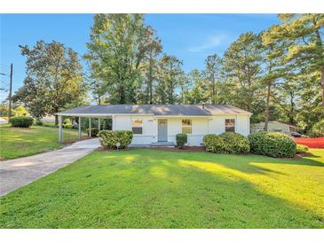 Charming single-story home features a cozy carport and well-manicured front lawn with lush greenery at 3650 Clovis Nw Ct, Atlanta, GA 30331