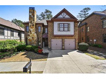 Charming two-story brick home featuring a stone chimney, attached two-car garage, and manicured landscaping at 4782 Lakeway, Alpharetta, GA 30005