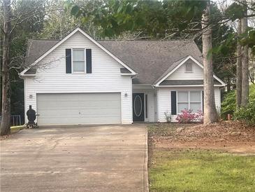 Charming home with a two-car garage, black shutters, and mature trees at 355 Freeman Dr, Covington, GA 30016