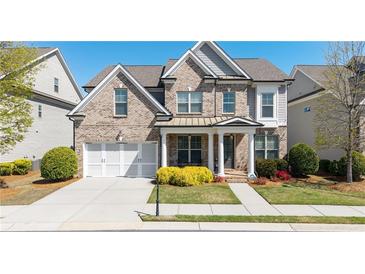 Charming two-story brick home with a well-manicured lawn and attached two-car garage at 930 Crestview Dr, Johns Creek, GA 30024