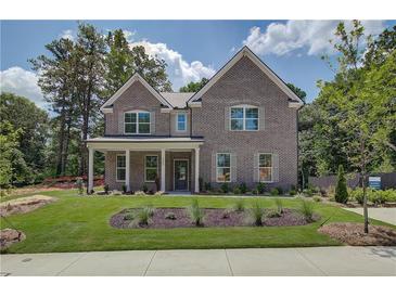 Charming two-story brick home with a manicured lawn and inviting front porch, perfect for enjoying the outdoors at 4504 Ajo Lot#2 Walk, Atlanta, GA 30331