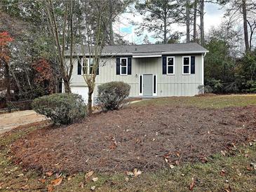 Charming home featuring a neatly landscaped front yard and gray exterior with dark shutters at 4232 Chickasaw Trl, Douglasville, GA 30135