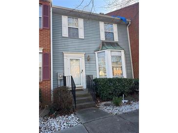 Charming two-story townhouse featuring classic siding, a decorative bay window, and landscaped front yard at 6438 Wedgeview Dr, Tucker, GA 30084