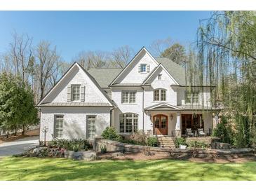 Stunning painted brick home featuring manicured landscaping and a charming front porch at 3224 Lanier Ne Dr, Atlanta, GA 30319