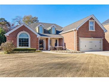 Charming two-story brick home featuring an attached garage and manicured front yard at 2105 Rotunda Ct, Conyers, GA 30094