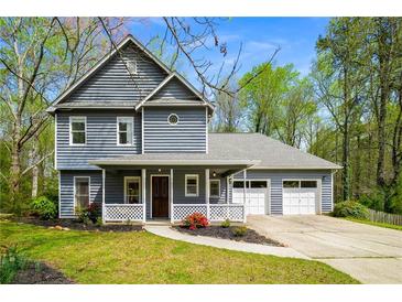 Charming two-story home with a covered front porch, attached garage, and well-manicured lawn and landscape at 3021 Favor Pines Sw Ct, Marietta, GA 30060