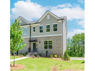 Charming townhome with brick facade, gray siding, manicured lawn and inviting front entrance at 1250 Ainsworth Aly # 42, Sugar Hill, GA 30518