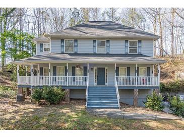 Charming two-story home with a welcoming front porch and blue accents, nestled among trees at 2887 Swarthmore Dr, Lawrenceville, GA 30044