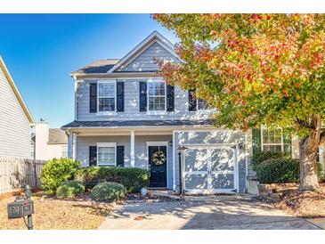 Charming two-story home featuring gray siding, black shutters, a welcoming front porch, and a manicured front yard at 840 Ash St, Canton, GA 30114