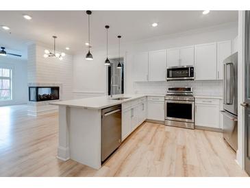 Bright kitchen with stainless steel appliances, white cabinets, and an island that opens to the living room at 625 Piedmont Ne Ave # 2004, Atlanta, GA 30308