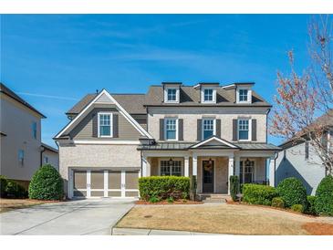 Charming two-story home featuring a welcoming front porch, attached two-car garage, and manicured landscaping at 4425 Atwood Dr, Cumming, GA 30040