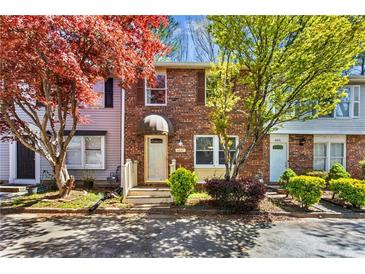 Charming brick townhouse with mature trees and well-manicured landscaping offers great curb appeal at 8827 Applegate Ln, Atlanta, GA 30350