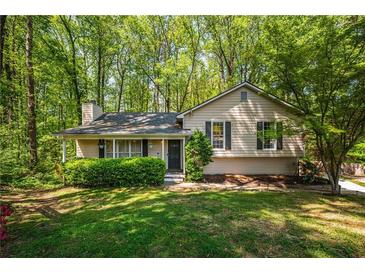 Charming single-story home with a well-manicured lawn and mature trees at 1131 Hershey Dr, Marietta, GA 30062