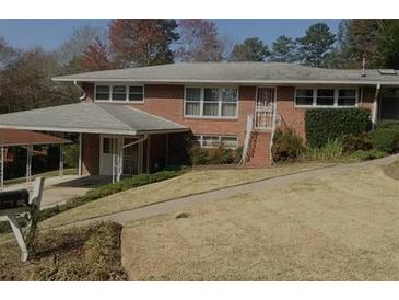 Charming brick home featuring a covered parking area, classic design elements, and a well-maintained lawn at 454 Jo Ann Se Dr, Marietta, GA 30067