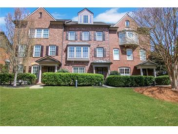 Charming brick townhouse featuring a well-manicured lawn and classic architectural details at 552 Micayne Se Cir # 1, Smyrna, GA 30082