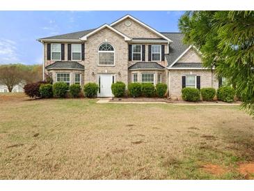 Inviting brick two-story home featuring a manicured front lawn with neatly trimmed shrubbery at 552 Trotters Ln, Mcdonough, GA 30252