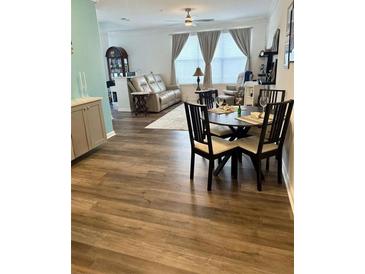 Well-lit dining area features wood floors and seating for four next to a comfortable living room with natural lighting at 400 17Th Nw St # 2031, Atlanta, GA 30363