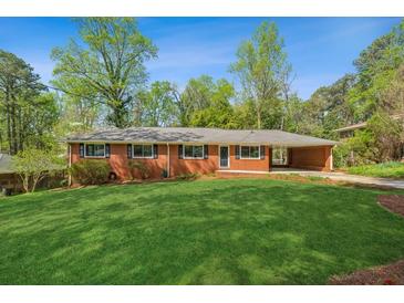 Charming brick home with a well-manicured lawn, carport, and mature trees at 681 Counsel Dr, Marietta, GA 30068