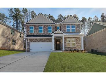 Traditional two-story brick home with a two-car garage and manicured lawn on a sunny day at 616 Leafy Branch Way, Mcdonough, GA 30253