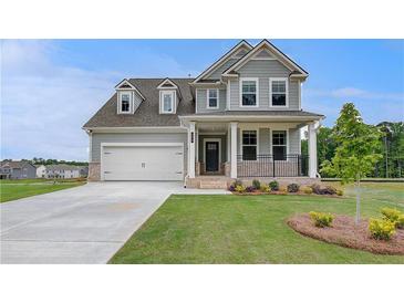 Charming two-story home showcasing a manicured lawn and inviting front porch at 255 Arnewood Cir, Mcdonough, GA 30253