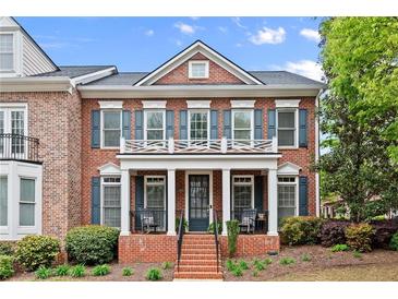 Charming two-story red brick home with a welcoming front porch and manicured landscaping at 4900 Fairmont Way, Roswell, GA 30075