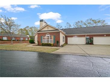Charming brick home featuring a two-car garage, well-kept lawn and manicured landscape at 460 Tribble Gap Rd # 1004, Cumming, GA 30040