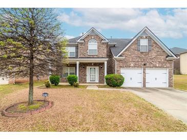 Charming brick home featuring a two-car garage, well-manicured lawn, and inviting front porch at 3019 Iona Ct, Snellville, GA 30039